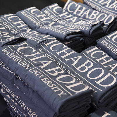 A stack of t-shirts that say Ichabod.